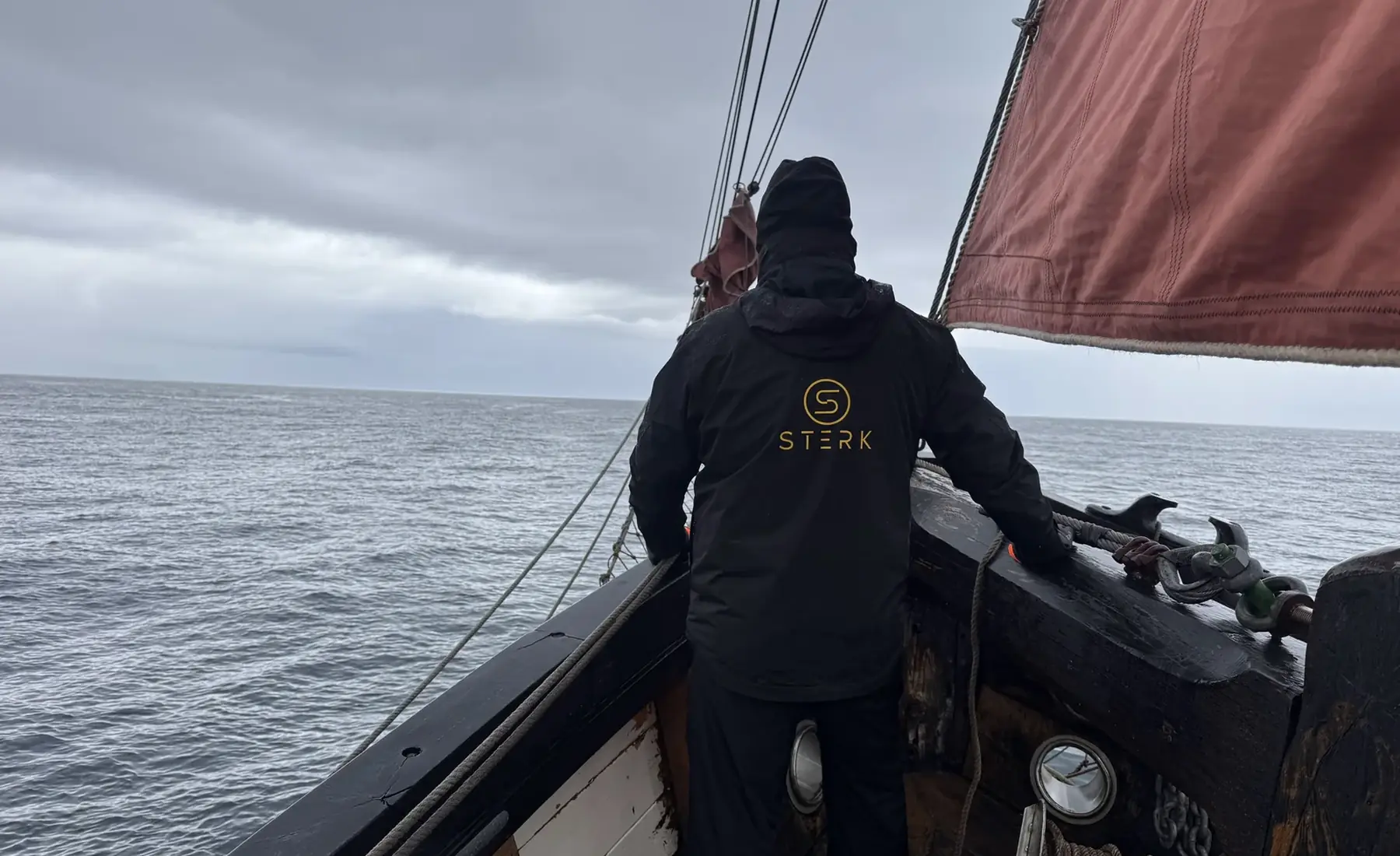 Person wearing a STERK jacket aboard a Faroese sailing vessel on the North Atlantic