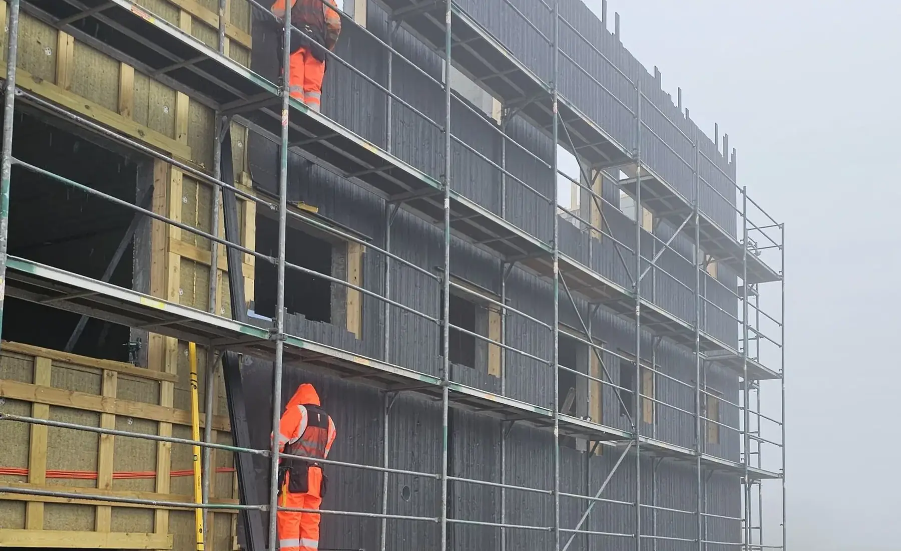 STERK crew on scaffolding at a timber-façade construction site in the Faroe Islands